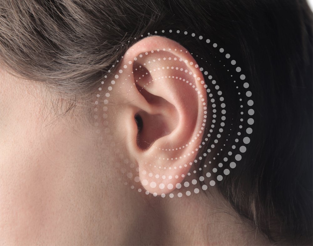 A close-up of a woman's ear adorned with small, decorative dots, highlighting unique body art or fashion statement.jpg